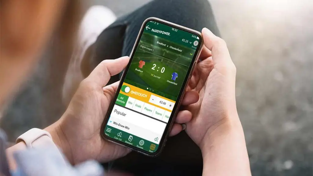 Person using a mobile betting app during a live football match.