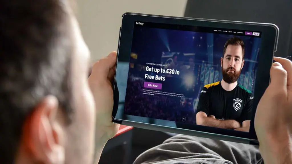 Person using a tablet while reviewing an online betting account registration page.